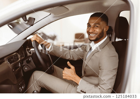 Great Car. African Businessman Gesturing Thumbs Up Sitting In Driver's Seat In Auto Dealership Shop. Selective Focus Great Car. African Businessman Gesturing Thumbs Up Sitting In Driver's Seat In Auto Dealership Shop. Selective Focus 125184033
