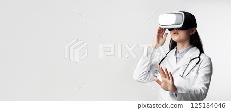 Innovative Medicine. Female Doctor Wearing Virtual Reality Glasses Over White Studio Background. Free Space Innovative Medicine. Female Doctor Wearing Virtual Reality Glasses Over White Studio Background. Free Space 125184046