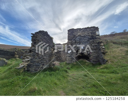 Old Castle Ruins Surrounded By Meadows and Green Fields 125184258