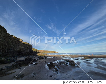 Coastal Highland Landscape with Watercourse and Mountains Under Cloudy Sky 125184259