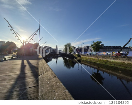Lake Landscape with Trees and City in the Background under a Cloudy Sky 125184295