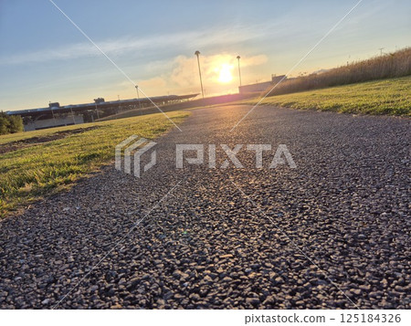 Sunny Road in a Natural Landscape with Plants and Clouds 125184326