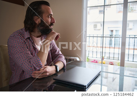 Thoughtful Young Man at Home Office Planning Future Projects Thoughtful Young Man at Home Office Planning Future Projects 125184462