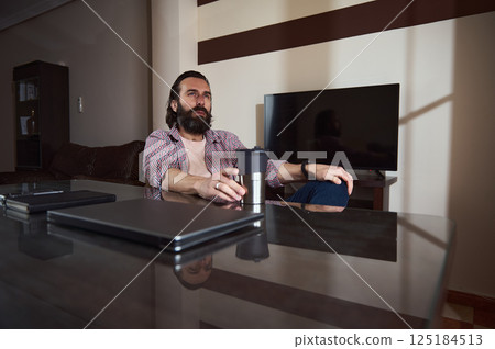 Young Professional Relaxing at Home Office With Work Materials Young Professional Relaxing at Home Office With Work Materials 125184513