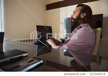 Entrepreneur Working Remotely on Laptop in Modern Home Office 125184519