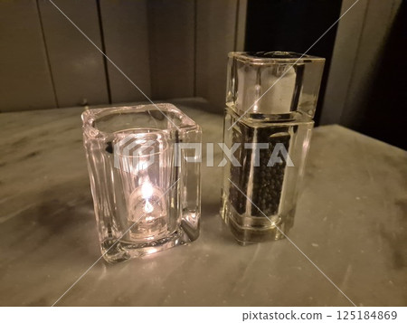 Candle and pepper on a restaurant table background 125184869