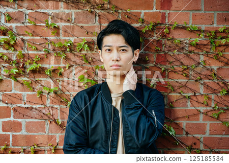 一名 20 多歲、穿著便服的年輕男子 一名 20 多歲、穿著便服的年輕男子 125185584