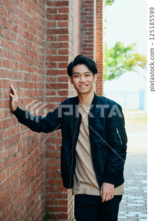 一名 20 多歲、穿著便服的年輕男子 一名 20 多歲、穿著便服的年輕男子 125185599