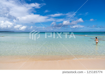 Woman with snorkel enters crystal-clear water for snorkeling in Okinawa, Japan 125185774