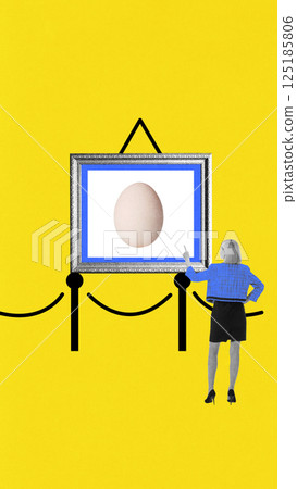 Minimalist egg framed as gallery artwork viewed by woman in blue, symbolizing fragile value of essentials. 125185806