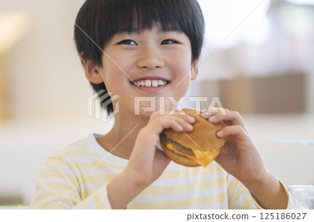 吃漢堡的微笑 9 歲男孩 125186027
