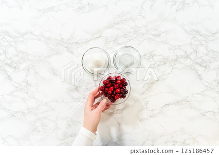 A close-up of cranberries and sugar, ready to be used in a cranberry buttercream sauce for the Lemon Spritz Cookies. A close-up of cranberries and sugar, ready to be used in a cranberry buttercream sauce for the Lemon Spritz Cookies. 125186457