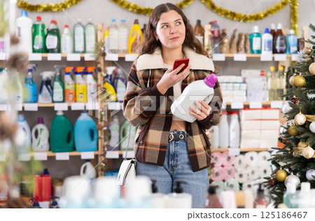 Young woman scanning qr code for detergent Young woman scanning qr code for detergent 125186467