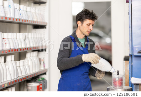 Man auto colorist combines different paint colors Man auto colorist combines different paint colors 125186591