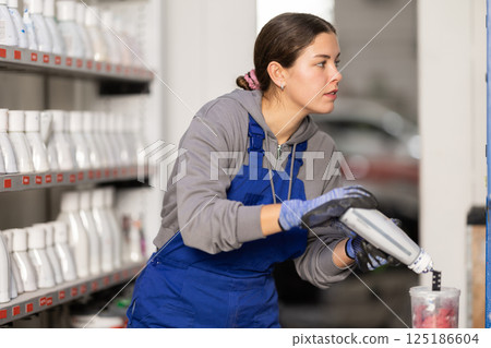 Girl auto colorist combines different paint colors Girl auto colorist combines different paint colors 125186604