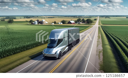 The suns morning rays cast a warm glow over lush fields, where an electric truck cruises smoothly along the open road, symbolizing a new era of sustainable agriculture and transport. 125186657