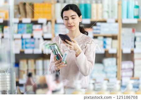 Young woman scanning qr code of toothbrush 125186708