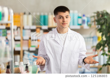Male pharmacist standing behind counter in pharmacy Male pharmacist standing behind counter in pharmacy 125186803