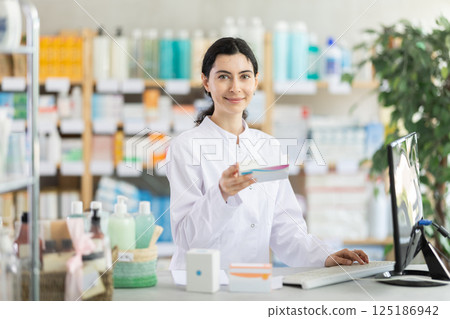 Female pharmacist searches for information about medicines on Internet 125186942