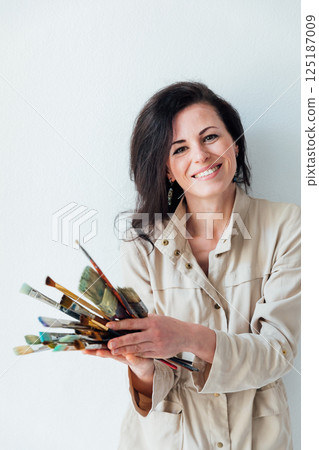 artist holding brushes in her hands to paint paintings artist holding brushes in her hands to paint paintings 125187009