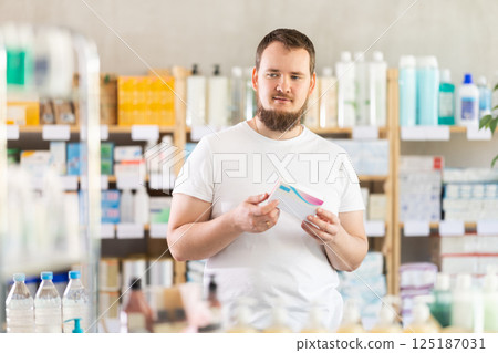 Man carefully selects pills in modern pharmacy 125187031