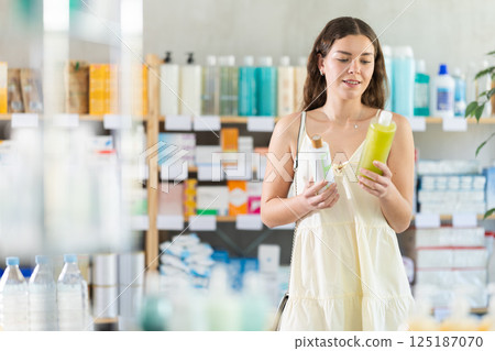 woman chooses a hair shampoo 125187070