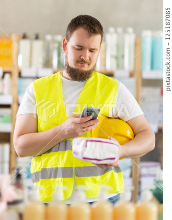 Checking expiration date of feminine pads - male builder scans QR code on label of feminine pads using smartphone Checking expiration date of feminine pads - male builder scans QR code on label of feminine pads using smartphone 125187085