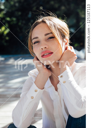 Portrait of a beautiful blonde woman fashionably walking on the street 125187113