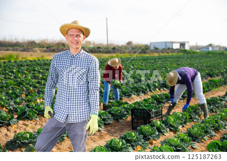 Portrait of man farmer in gloves standing in farm field Portrait of man farmer in gloves standing in farm field 125187263