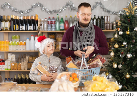 Man and his son buy food in a store Man and his son buy food in a store 125187316