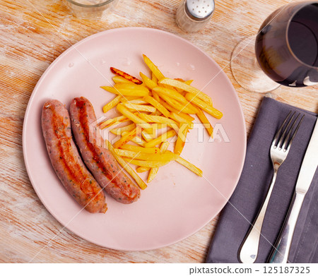 Grilled spicy sausages served with french fries Grilled spicy sausages served with french fries 125187325