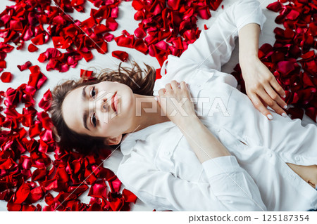 woman lying with red petals scent rose woman lying with red petals scent rose 125187354