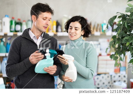 Couple man and woman scanning qr code for cleaning spray 125187409