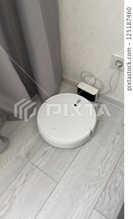 Modern white robot vacuum cleaner in the bathroom. Smart home concept. 125187460