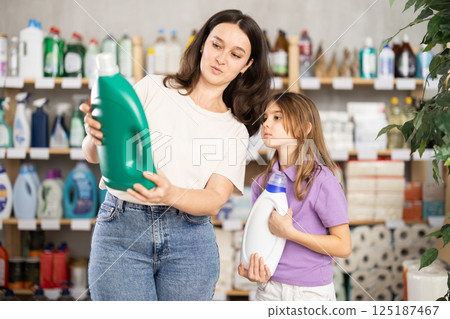 woman with a child chooses a detergent woman with a child chooses a detergent 125187467