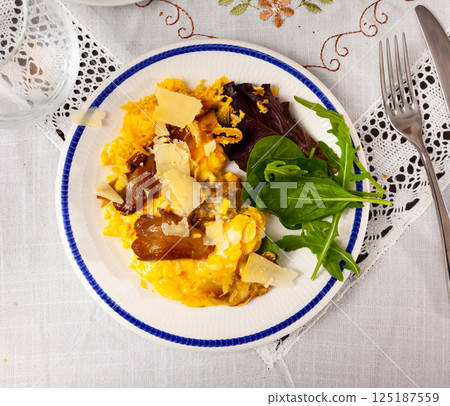 Scrambled eggs with mushrooms and cheese served with greens Scrambled eggs with mushrooms and cheese served with greens 125187559