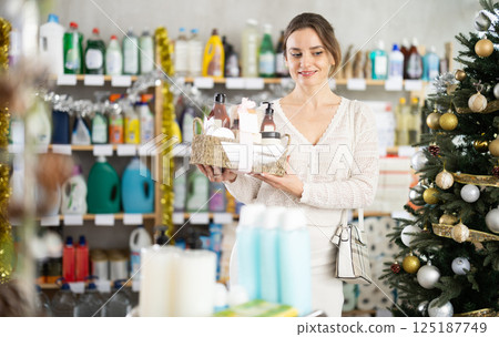 Young woman choosing gift basket in supermarket during X-mas 125187749