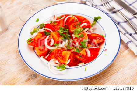 Vegetarian salad with tomatoes, onion, greens and olive oil 125187810