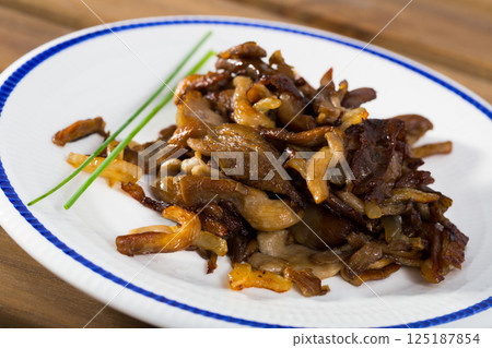 Tasty cooked fried oyster mushrooms at plate at table 125187854