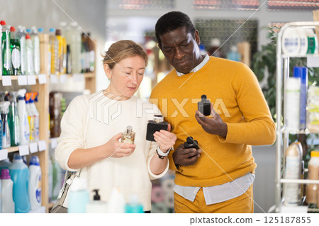 Woman with African man sniffs fragrance of perfume, chooses scent spray with pleasant smell Woman with African man sniffs fragrance of perfume, chooses scent spray with pleasant smell 125187855