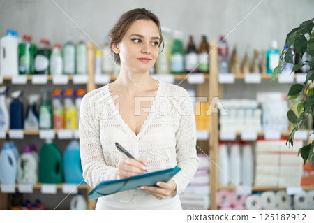 Young woman seller conducting inventory in store Young woman seller conducting inventory in store 125187912
