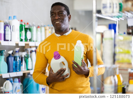 Before buying in household shop, African male customer choose liquid detergent Before buying in household shop, African male customer choose liquid detergent 125188073