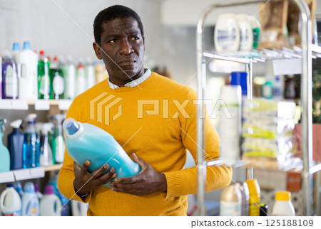 Male consumer with household chemical products for washing indoors Male consumer with household chemical products for washing indoors 125188109