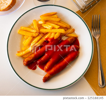 grilled sausages and slices of toasted potatoes 125188145