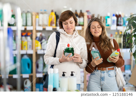 Mother and her adult daughter choose dishwashing liquid together in supermarket 125188146