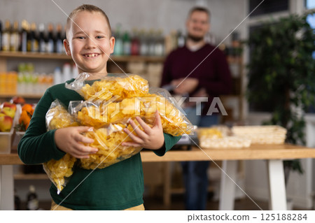 Boy choosing chips in grocery store Boy choosing chips in grocery store 125188284