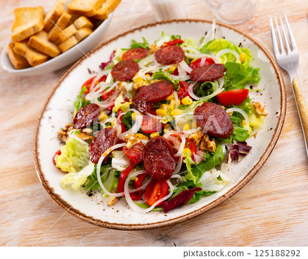 Vitamin salad of fresh vegetables, lettuce leaf, corn, bel pepper and chorizo. 125188292