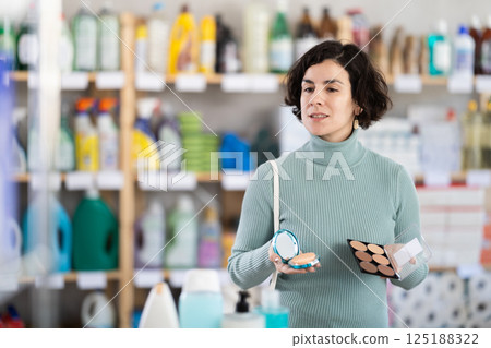 Middle-aged woman choosing cosmetics at supermarket Middle-aged woman choosing cosmetics at supermarket 125188322