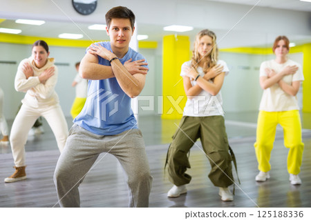 Emotional teen boy dancing with group of friends in dance studio. Hip hop generation 125188336