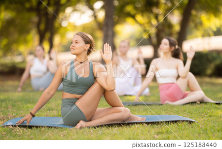 Yoga lesson visitors girls perform lord of fishes in park 125188440
